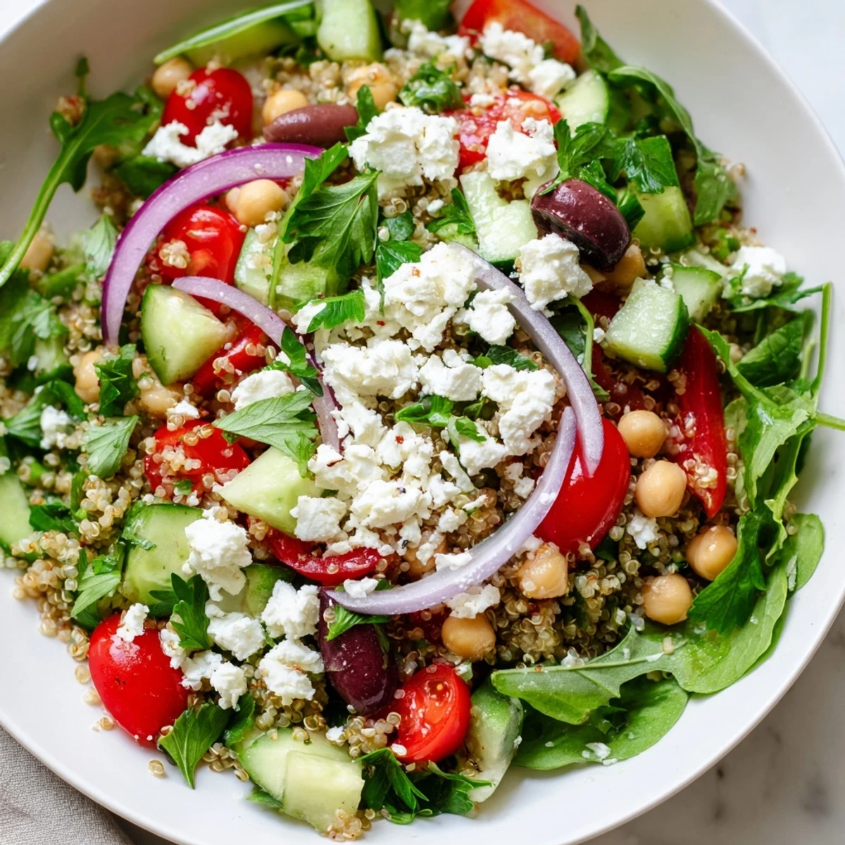 Colorful Mediterranean Supper Salad tossed with tangy dressing, Kalamata olives, and fresh parsley garnish.