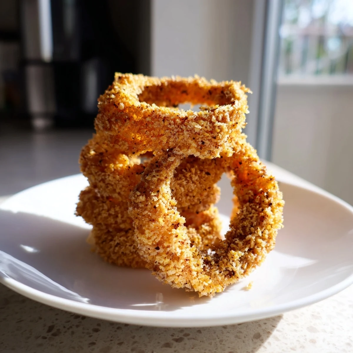 Freshly cooked Crispy Air Fryer Onion Rings piled high, showing their crunchy panko coating and tender onion center.