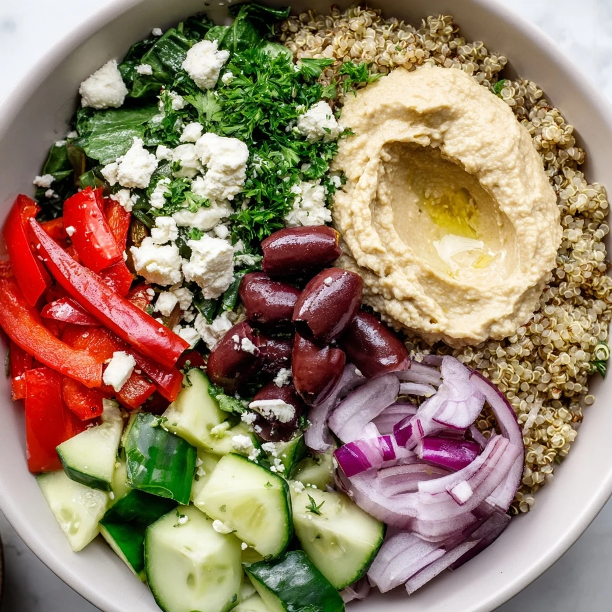 Nourishing Mediterranean Quinoa Bowl with Hummus featuring colorful tomatoes, cucumbers, and red peppers for a healthy meal.