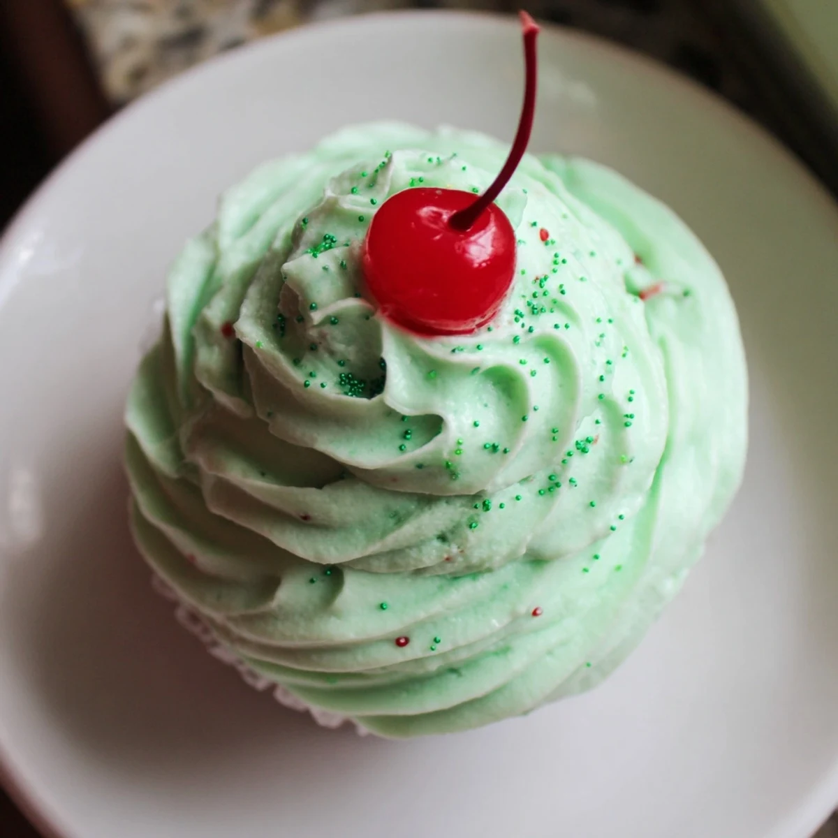 Freshly baked Shamrock Shake Cupcakes with mint frosting, served on a cooling rack with vivid green hue.