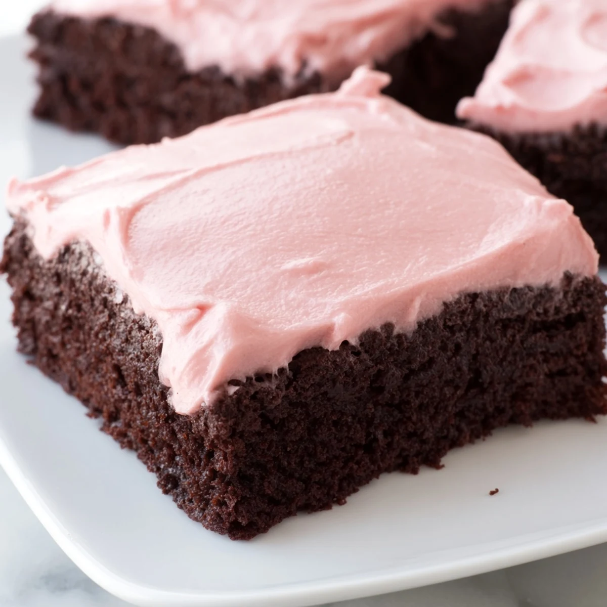Warm brownies with pink frosting are topped with extra sprinkles for a festive dessert platter.