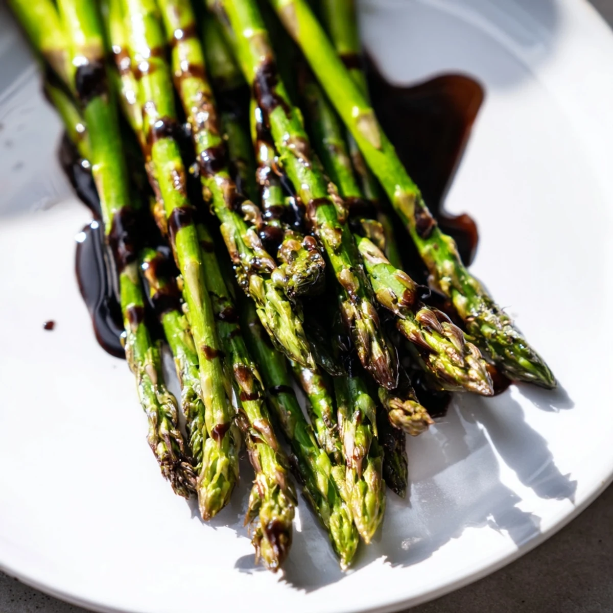 Roasted asparagus with balsamic glaze drizzled over spears, paired with crusty bread for dipping.