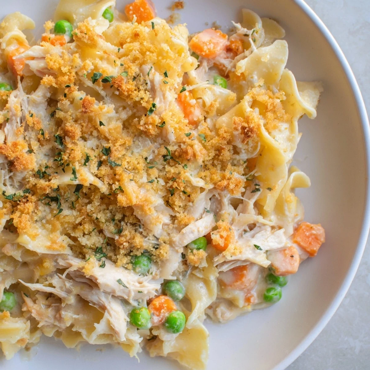 Steam rises from Chicken Noodle Casserole with Crumble served at family dinner.