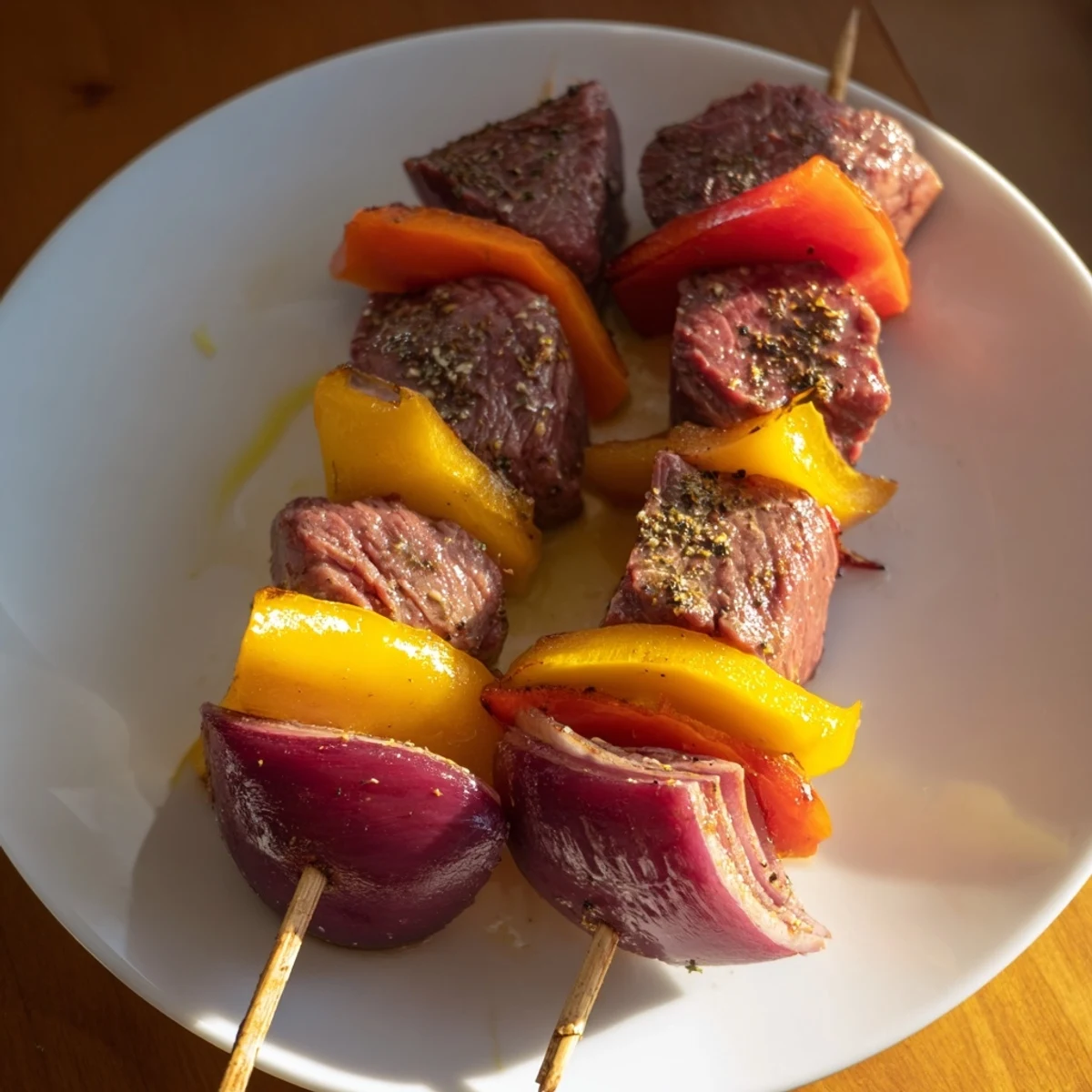 Juicy marinated beef cubes sizzling on the grill with vibrant red bell peppers and onions for a smoky flavor.