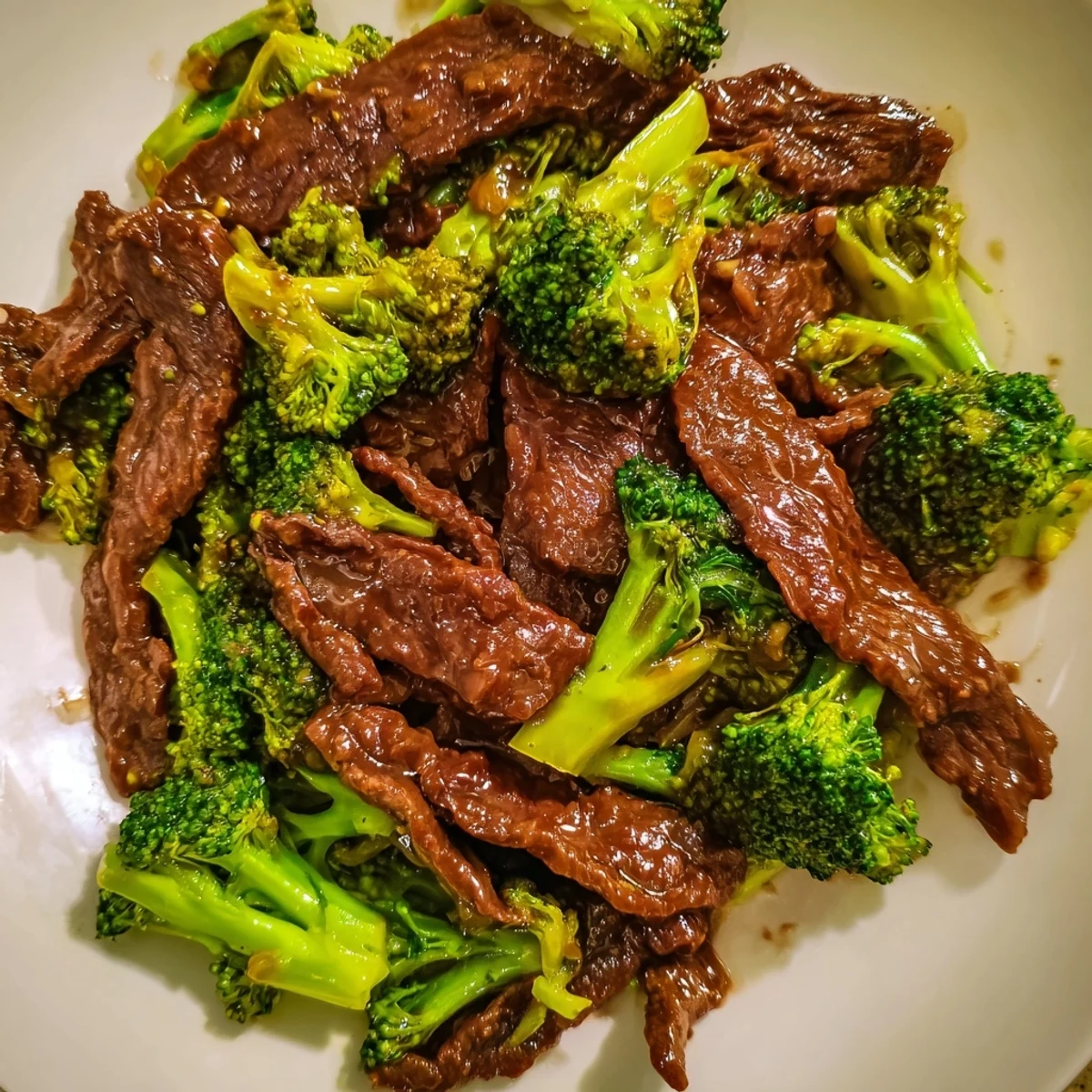 A close-up of vibrant Beef and Broccoli with Soy Sauce, featuring seared beef slices and bright green florets in a rich sauce.