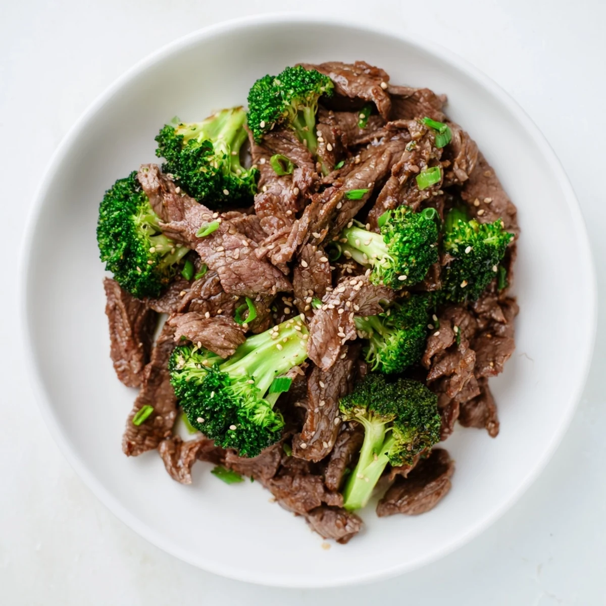 A close-up of glistening Beef and Broccoli with Soy Sauce Glaze showcasing saucy steak and vibrant broccoli florets.