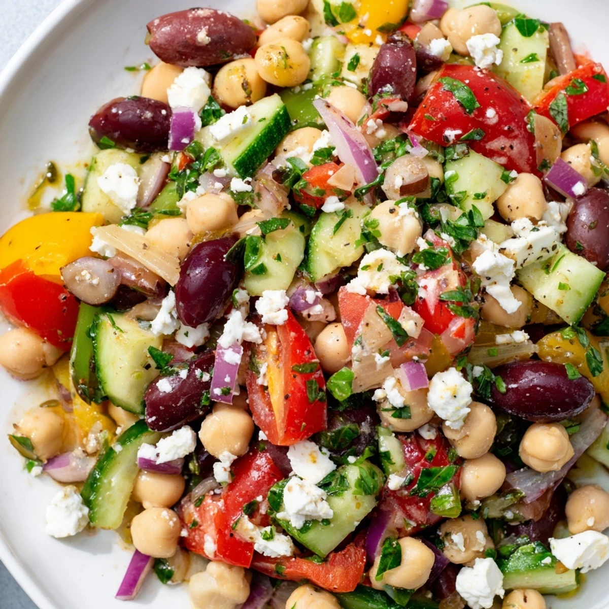 A colorful Mediterranean Dense Bean Salad tossed in a lemony herb dressing, served as a healthy side dish for a summer barbecue spread.