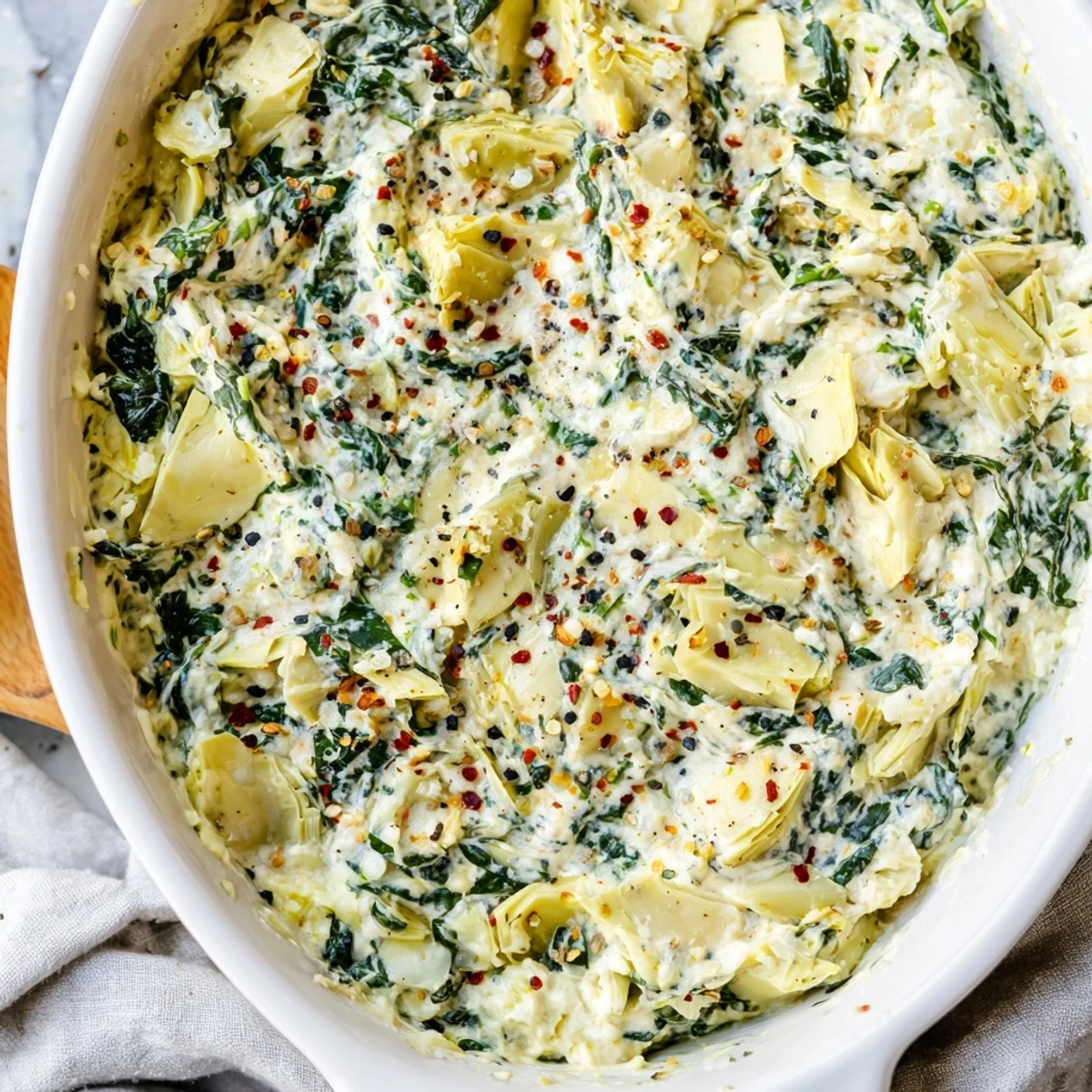 Warm, bubbly Spinach Artichoke Dip Ultimate Recipe fresh from the oven, served with crunchy tortilla chips.
