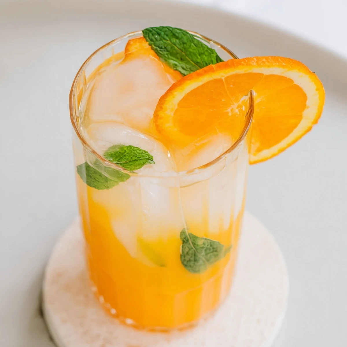 Golden ice cubes clink in tall glasses as bright orange juice meets chilled coconut water in this Refreshing Coconut Orange Glow.  