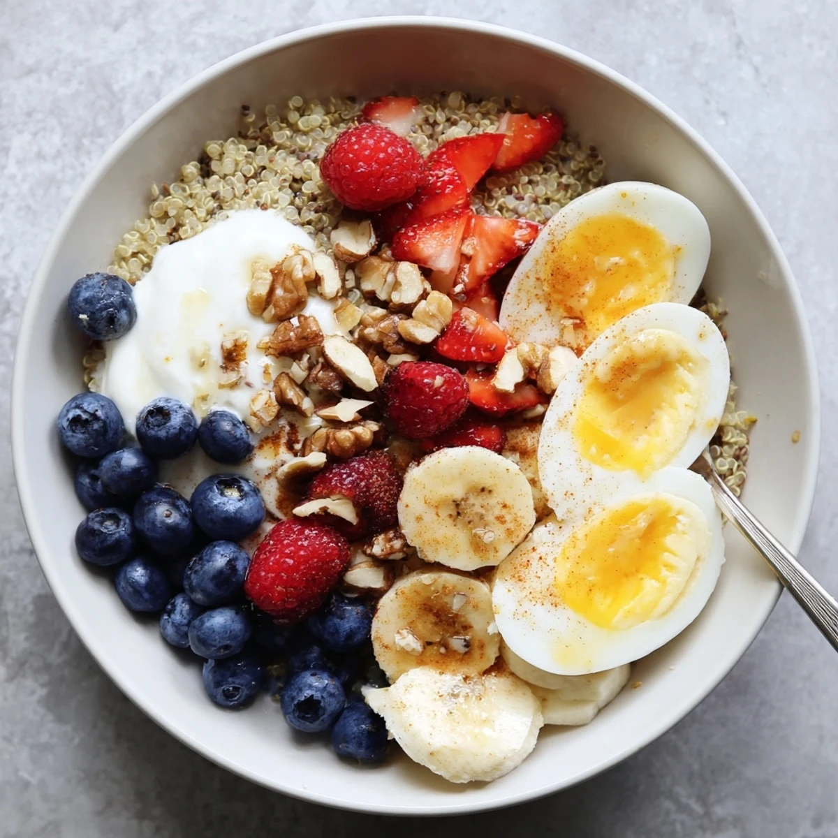 A vibrant Dietitians Balanced Breakfast Bowl features sliced banana, crunchy walnuts, and a sweet honey drizzle.