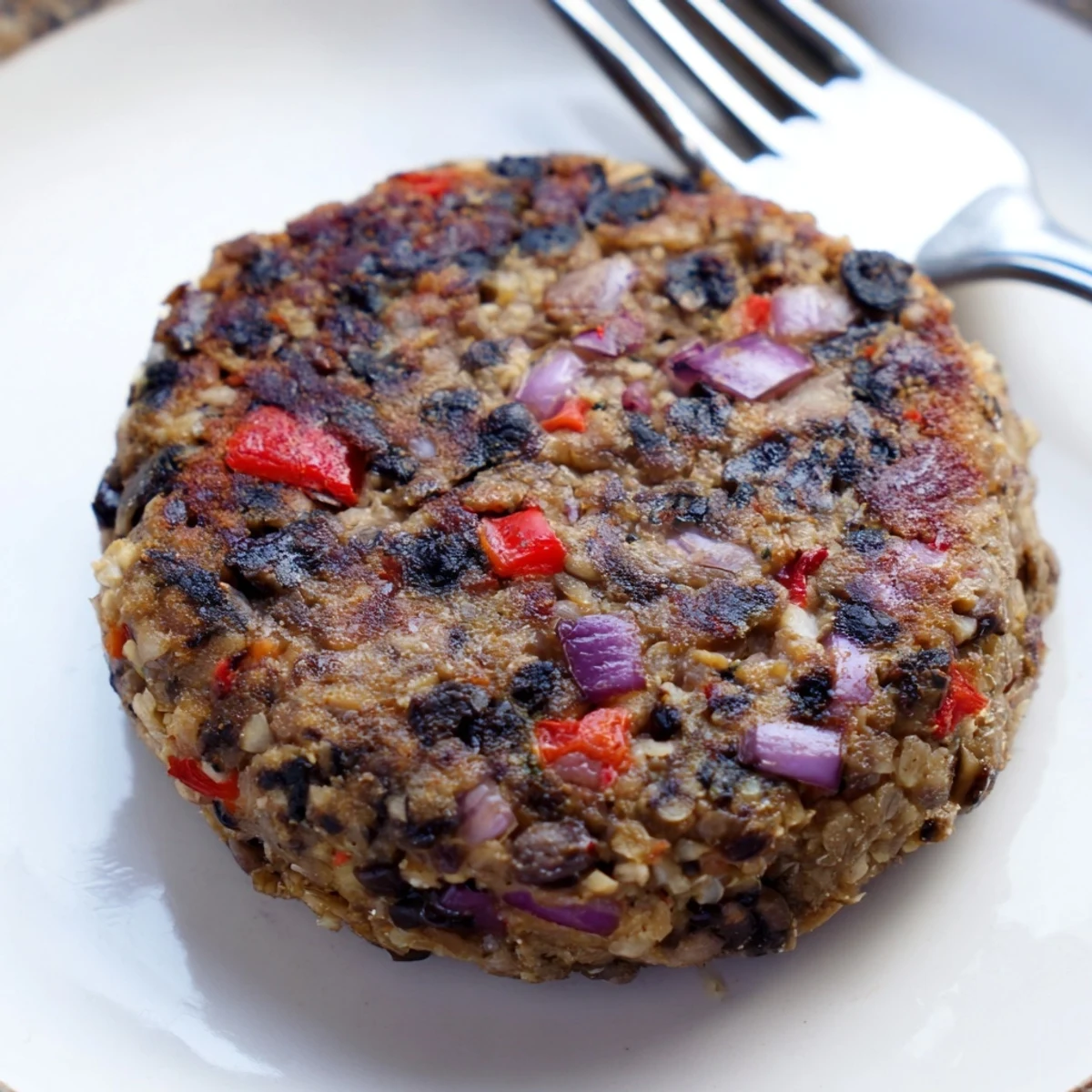 Golden-brown Mushroom Veggie Burgers sizzling in a skillet, topped with melted cheese and fresh lettuce.  