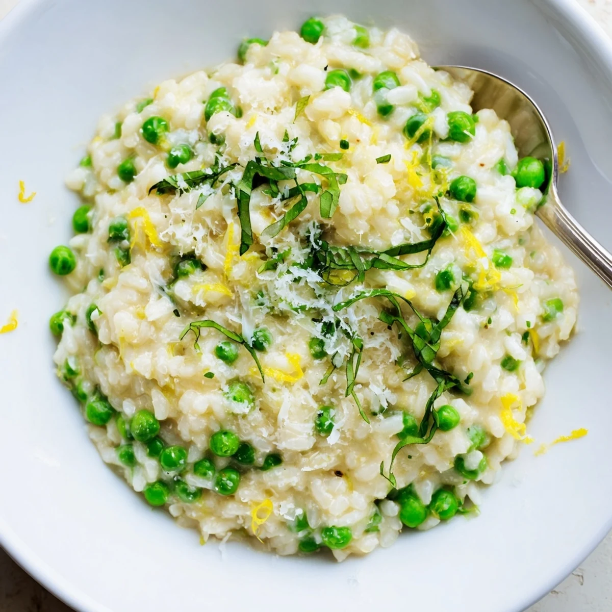 Golden Arborio rice studded with bright green peas in a rich Parmesan cheese sauce