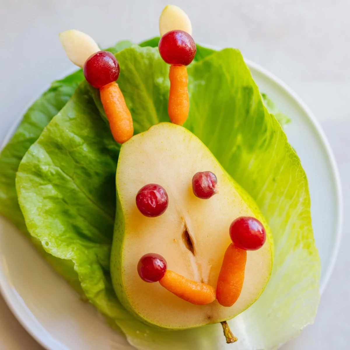Pear bunny salad arranged on fresh lettuce with raisin eyes and cherry nose