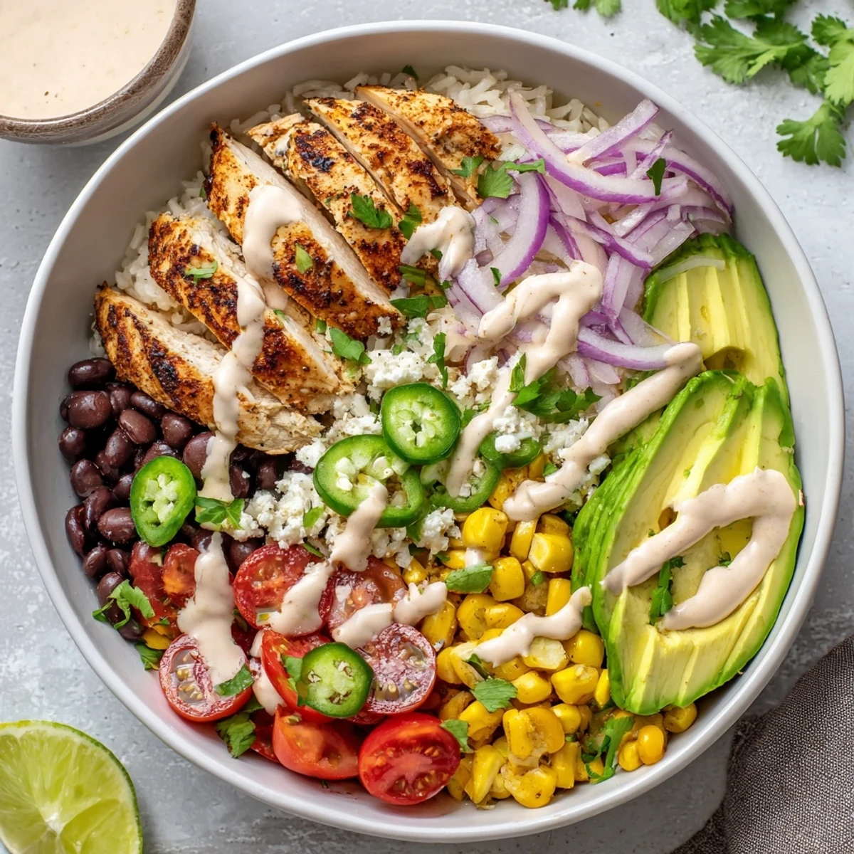 Vibrant Baja style chicken bowl featuring grilled chicken, avocado, corn, and creamy chipotle drizzle