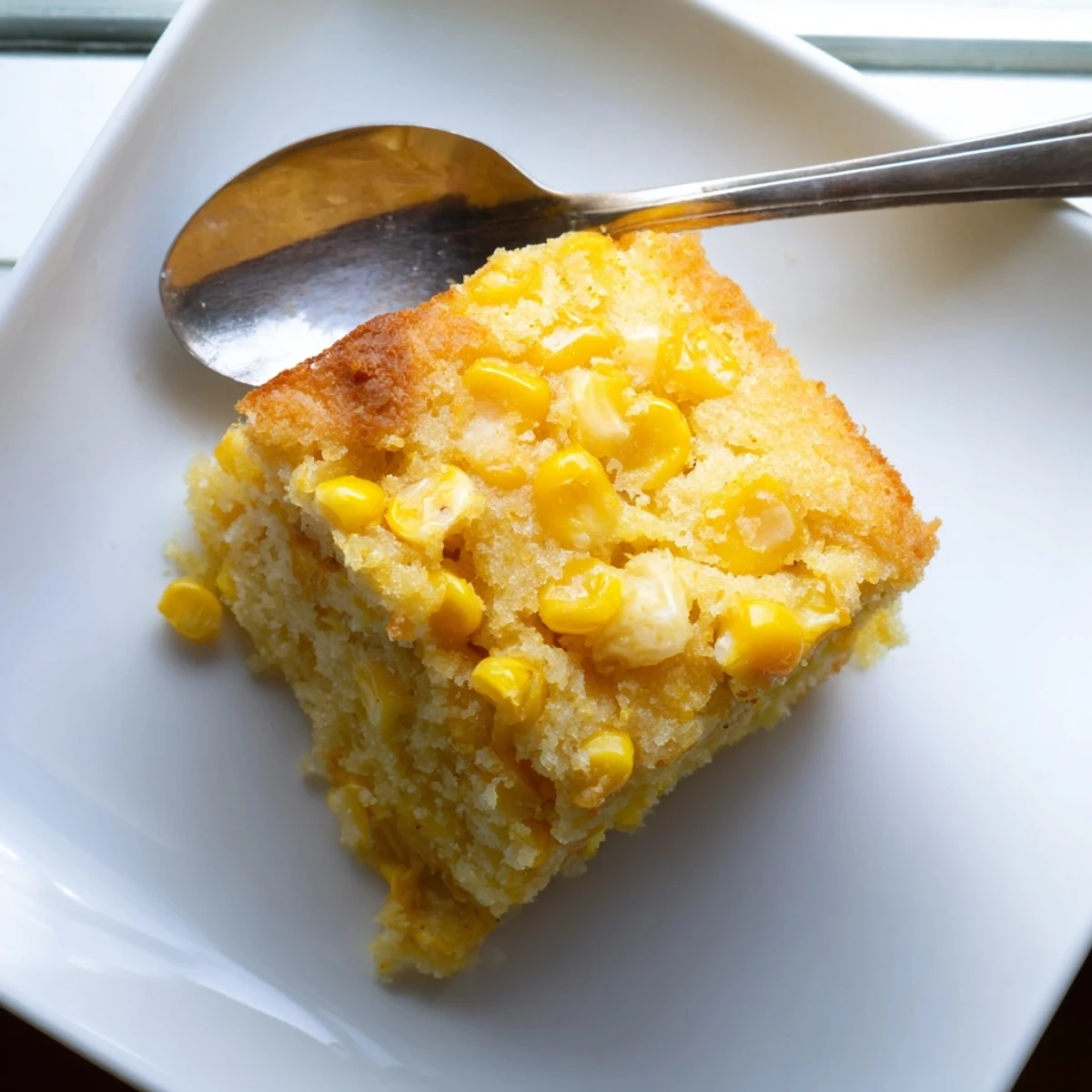 Golden brown Jiffy corn casserole with a creamy texture and buttery corn kernels