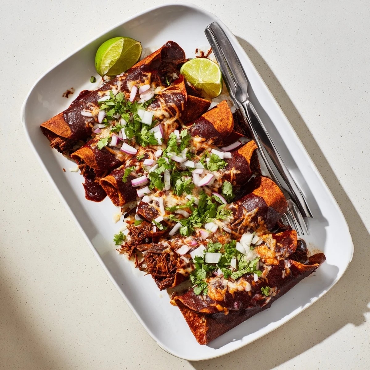 Homemade birria enchiladas with slow-cooked beef filling, drizzled with birria sauce and garnished with cilantro