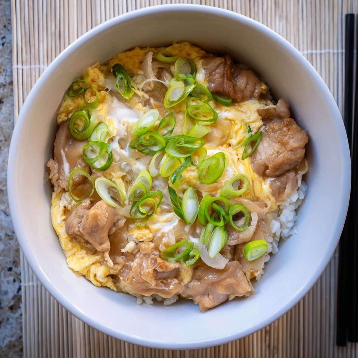 Homemade oyakodon with succulent chicken pieces in savory sauce nestled over fluffy Japanese rice