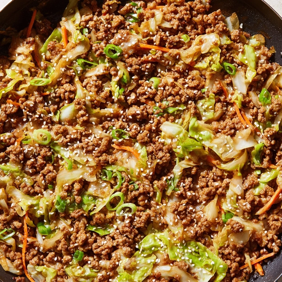 Hearty low-carb egg roll in a bowl featuring tender cabbage carrots and seasoned ground pork in a pan
