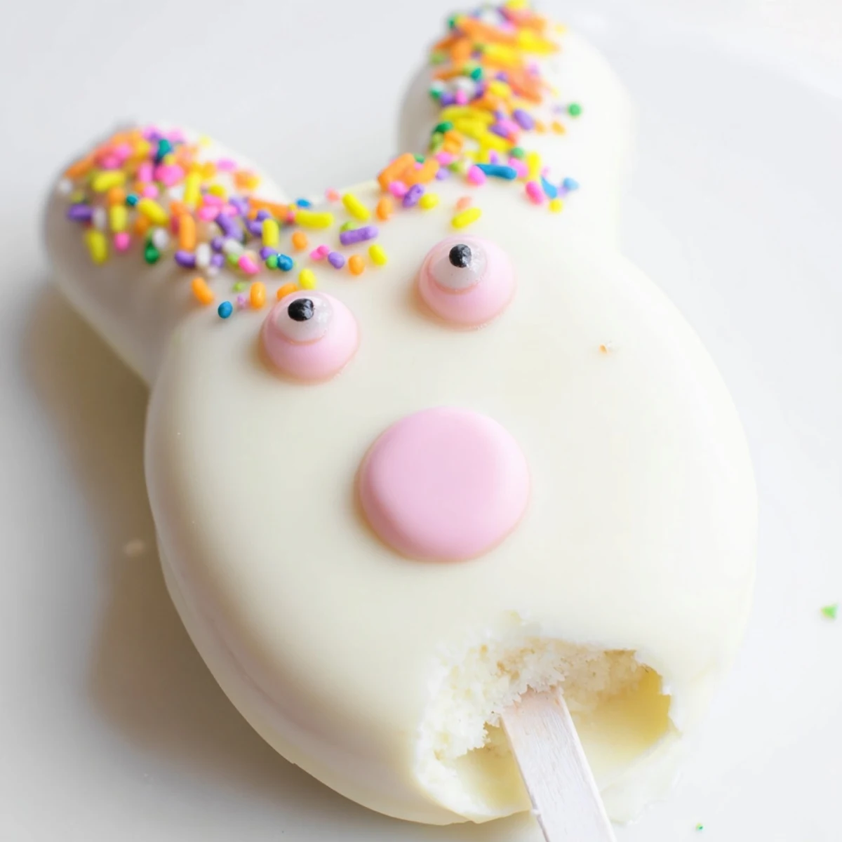 Adorable white chocolate bunny cakesicles with candy eyes and pink ears on sticks