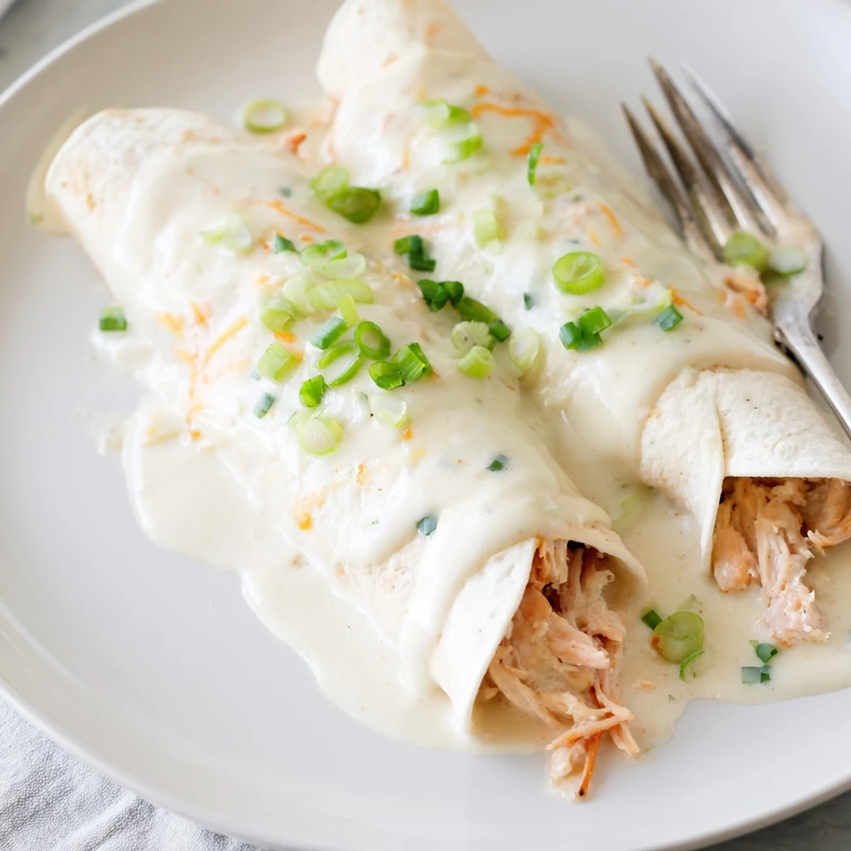 Smothered in velvety sauce, Creamy White Chicken Enchiladas topped with cilantro