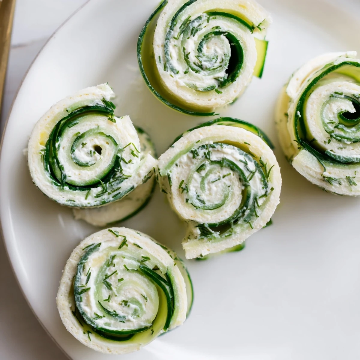 Handheld Cucumber And Dill Pinwheels sliced into spirals, soft tortillas, herb fragrance.