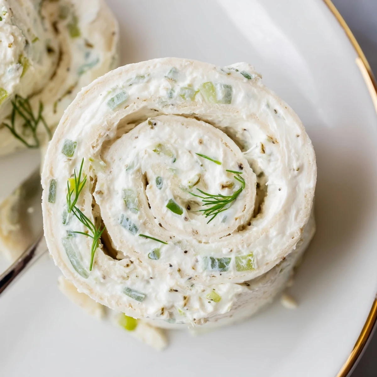 Chilled Pickle Dip Pinwheels, soft tortillas rolled tight, crunchy pickle bits