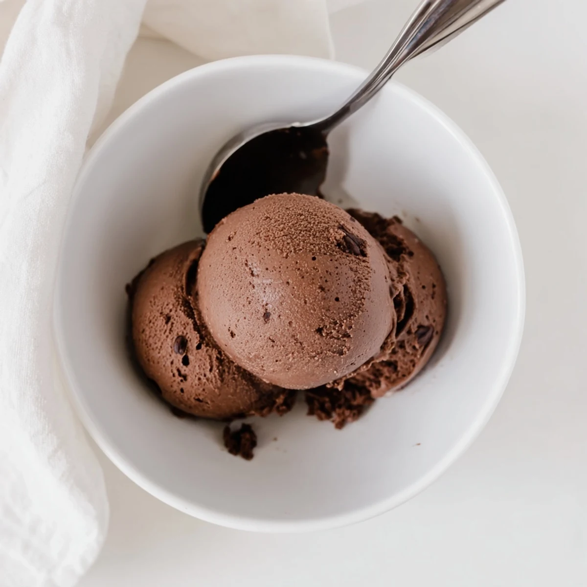Creamy chocolate sourdough ice cream scooped into a chilled glass bowl with dark chocolate shavings