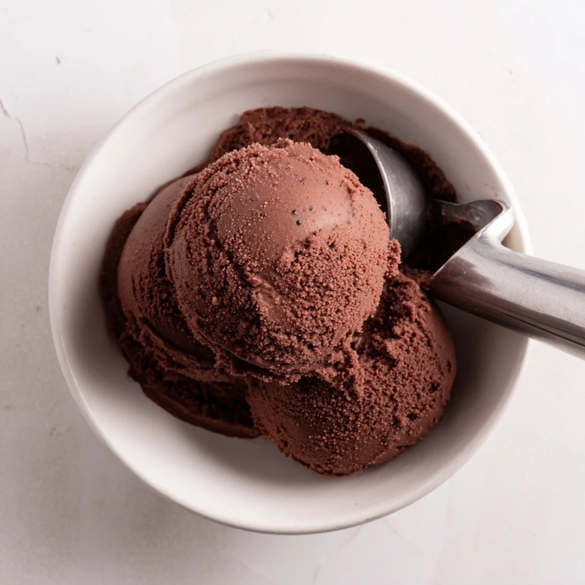 Homemade chocolate sourdough ice cream served in vintage porcelain bowl with wafer cookie garnish