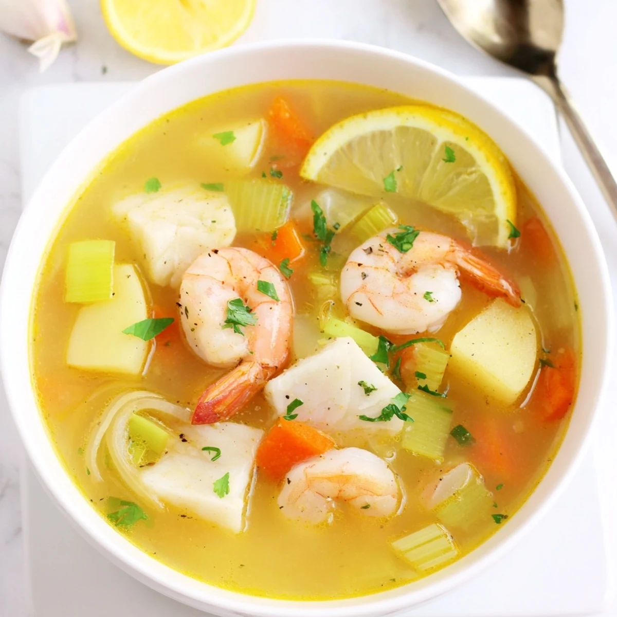 Seared shrimp-topped Fish Soup ladled into deep bowls, served with crusty bread