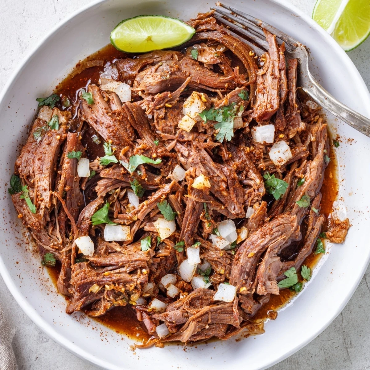 Slow Cooker Beef Barbacoa piled on warm tortillas, tender, smoky, juicy shreds