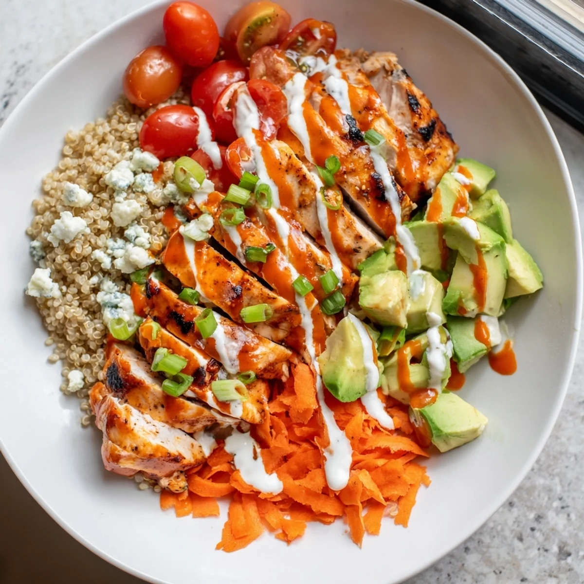 Spicy buffalo chicken grain bowl loaded with crisp veggies and creamy ranch dressing