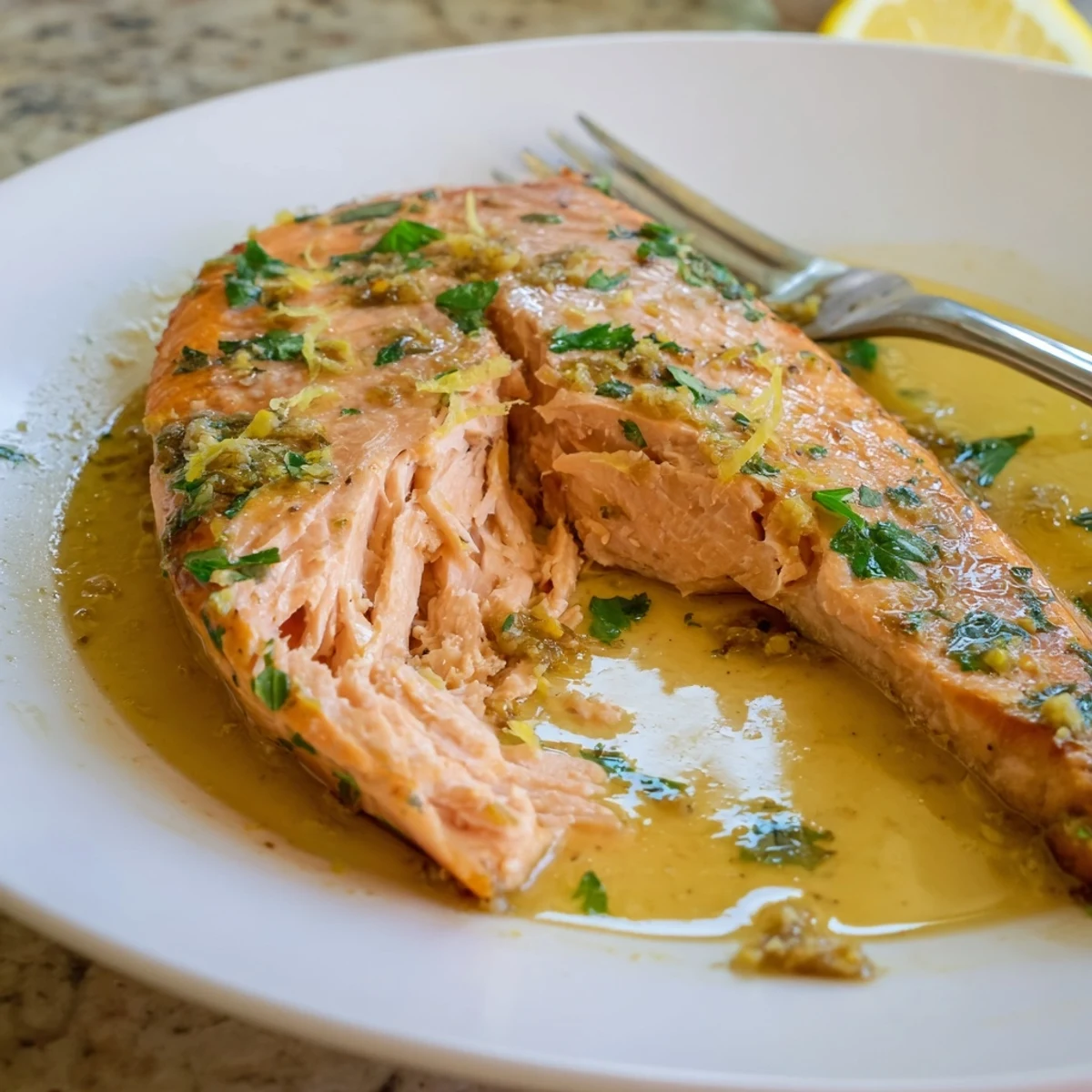 Juicy garlic butter salmon nestled in a rich, aromatic skillet with lemon wedges