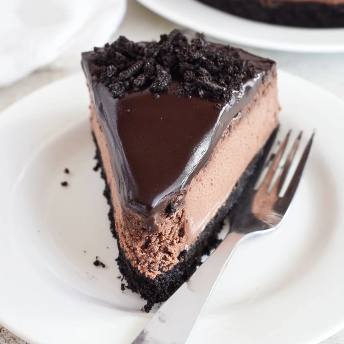 Decadent Oreo chocolate cheesecake recipe showing a creamy slice with chocolate crust and Oreo garnish.  