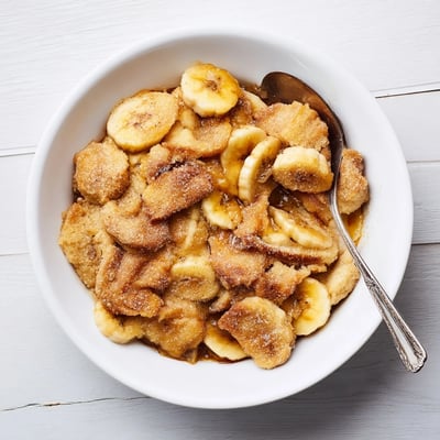 Warm Southern banana cobbler served with vanilla ice cream on a rustic plate