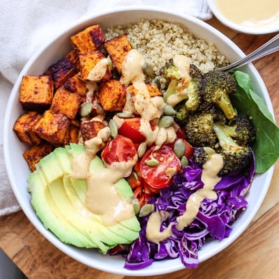 Golden roasted vegetables and avocado layered in a fresh vegan buddha bowl