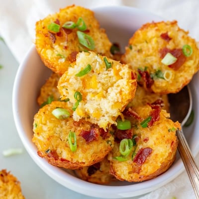 Savory appetizer of crispy hashbrown bites served with a side of cool sour cream.